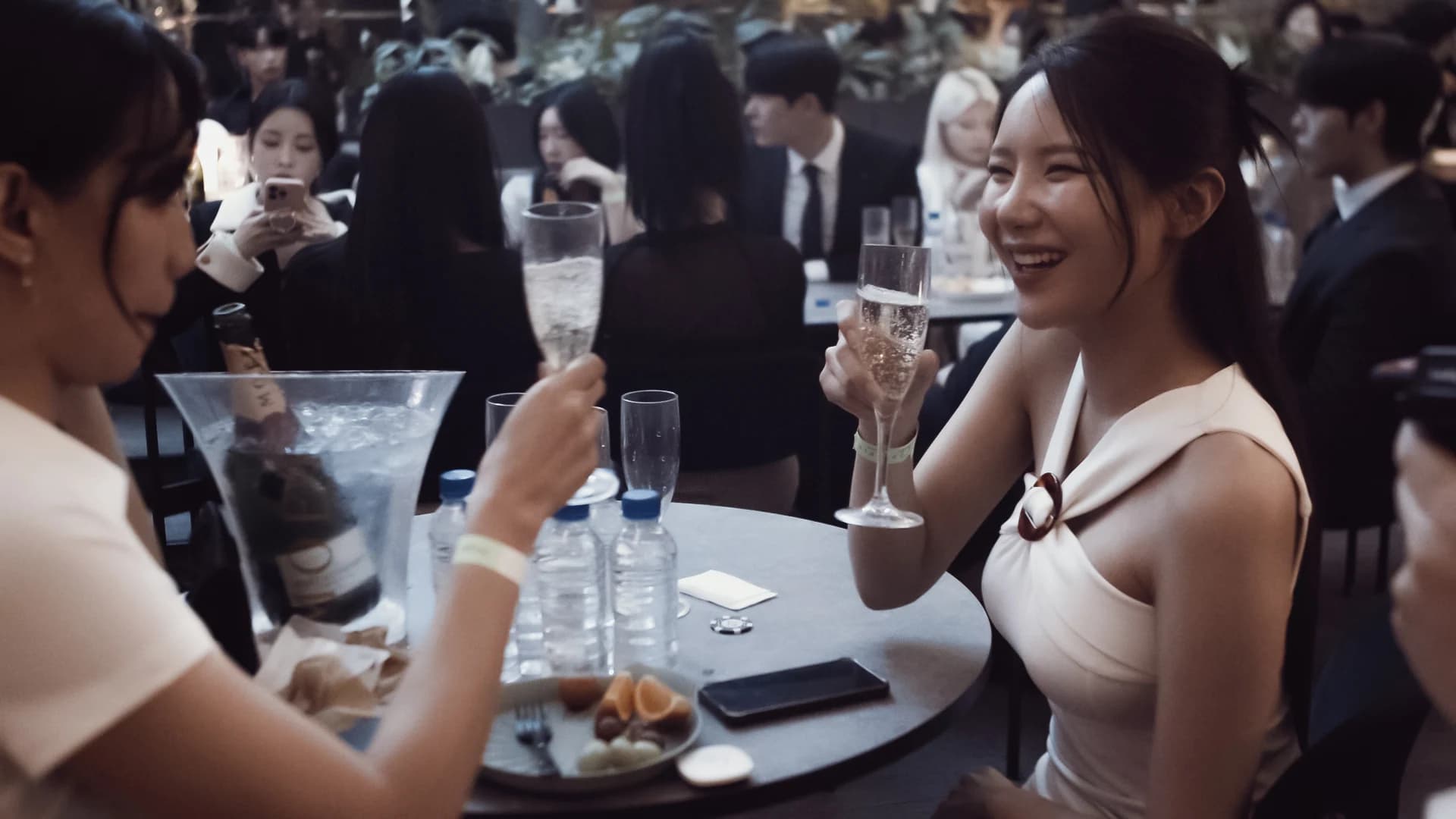 Guests laughing together around a table at a Felicity gathering.