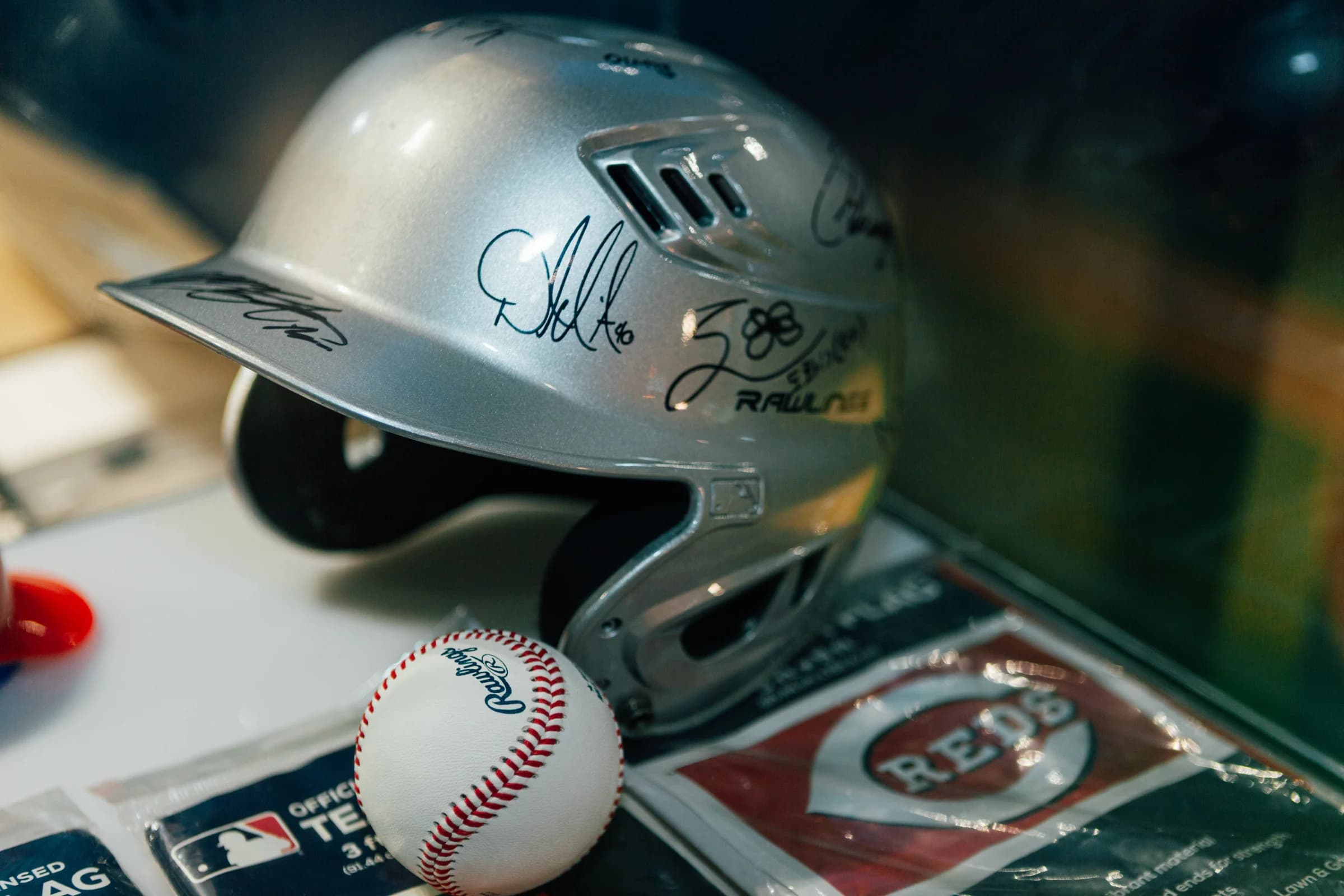 A signed baseball and helmet in a softly lit display.