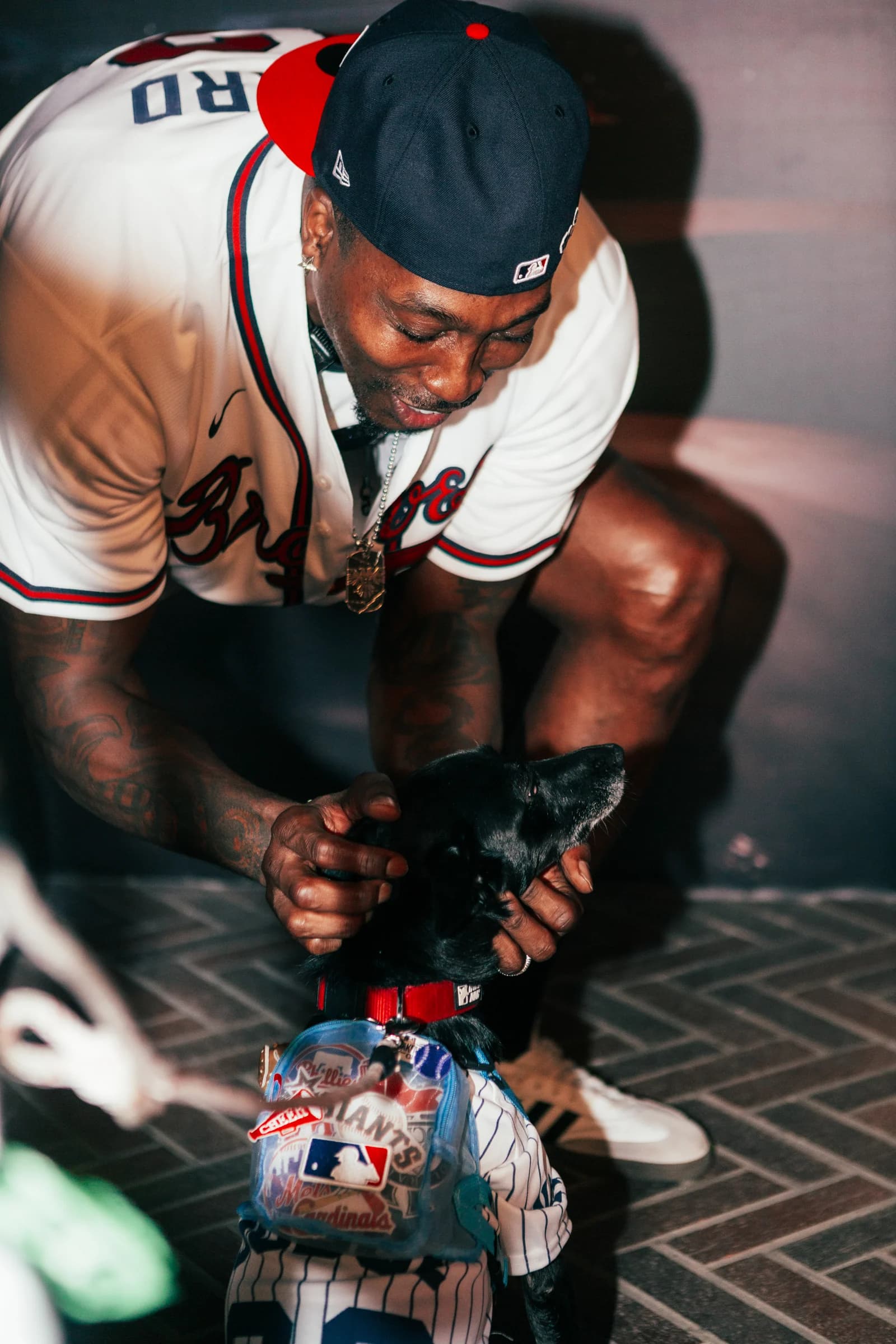 A baseball player bends down to sign memorabilia for a fan.